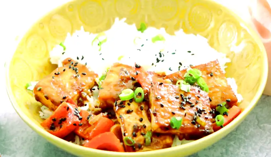 Bowl de tofu épicé et sucré avec des poivrons vibrants et des épices savoureuses, un plat végétarien ayurvédique sain et délicieux.